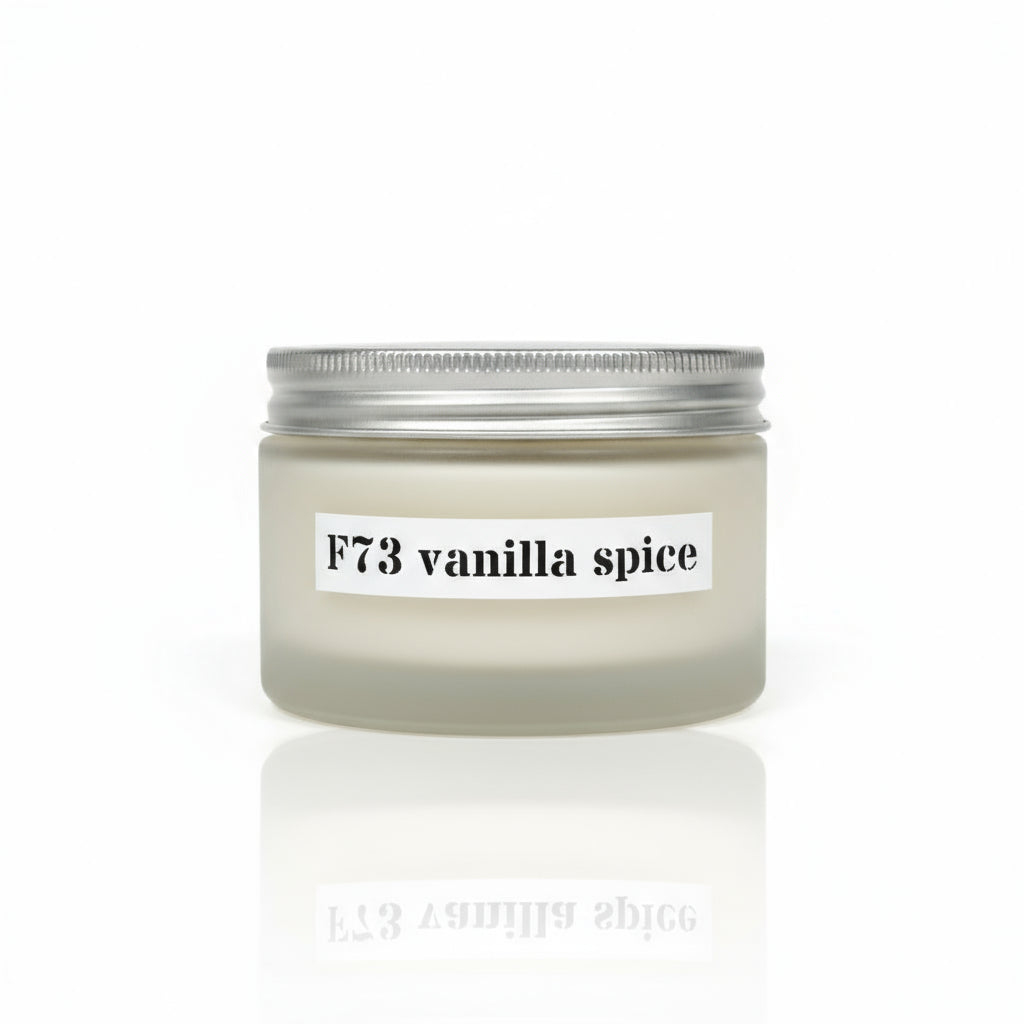 A jar of F73 vanilla spice aromatherapy body cream placed on a wooden surface with floral backgrounds.