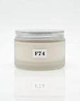 A jar of body cream labeled F74 SUMMER BREEZE BODY CREAM, placed on a wooden surface with floral background.