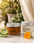 Formula Flawless F65 body polish and F73 Vanilla Noir body cream together on white marble