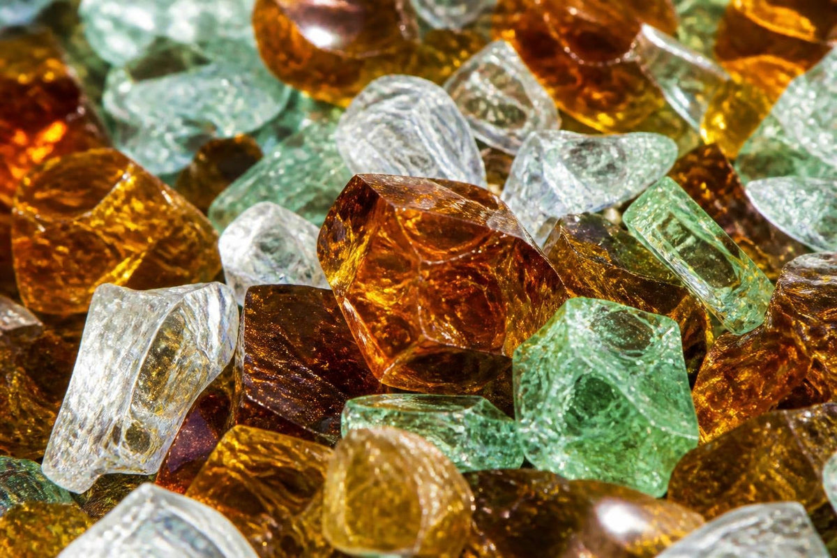Sunlit fragments of amber, clear and green recycled glass catching the light like cut stones