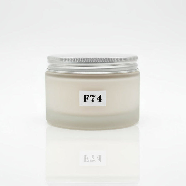 A jar of body cream labeled F74 SUMMER BREEZE BODY CREAM, placed on a wooden surface with floral background.